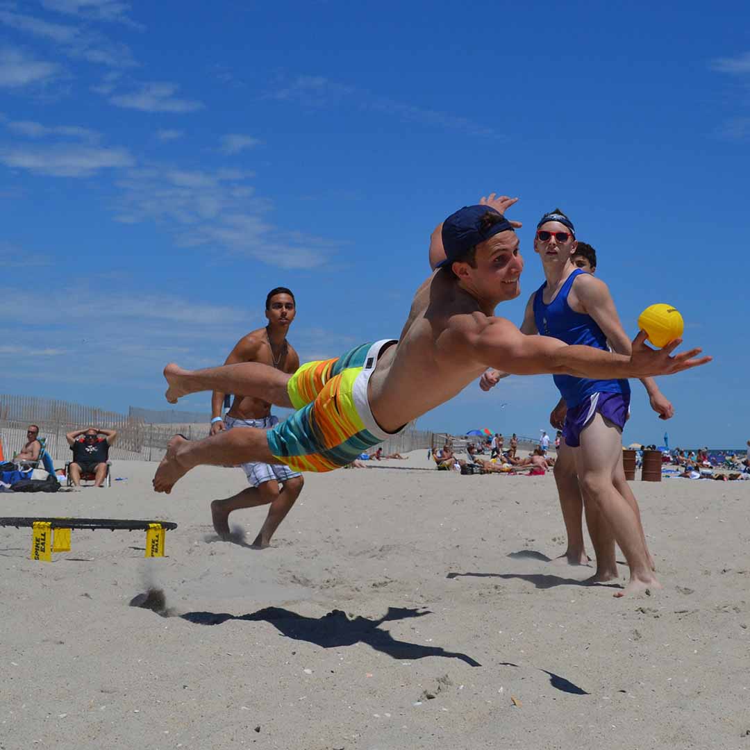 A man jumps to save a Spikeball game